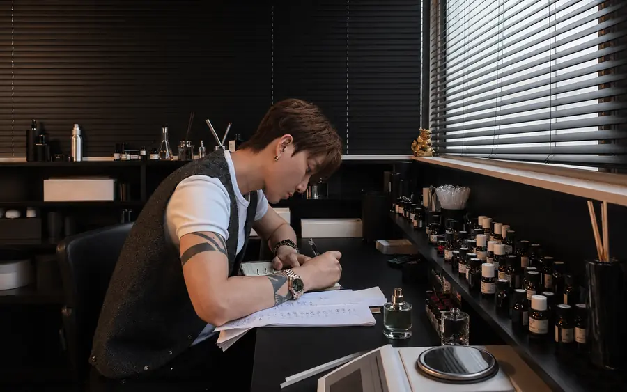 Aven Xu writing fragrance notes at the studio desk