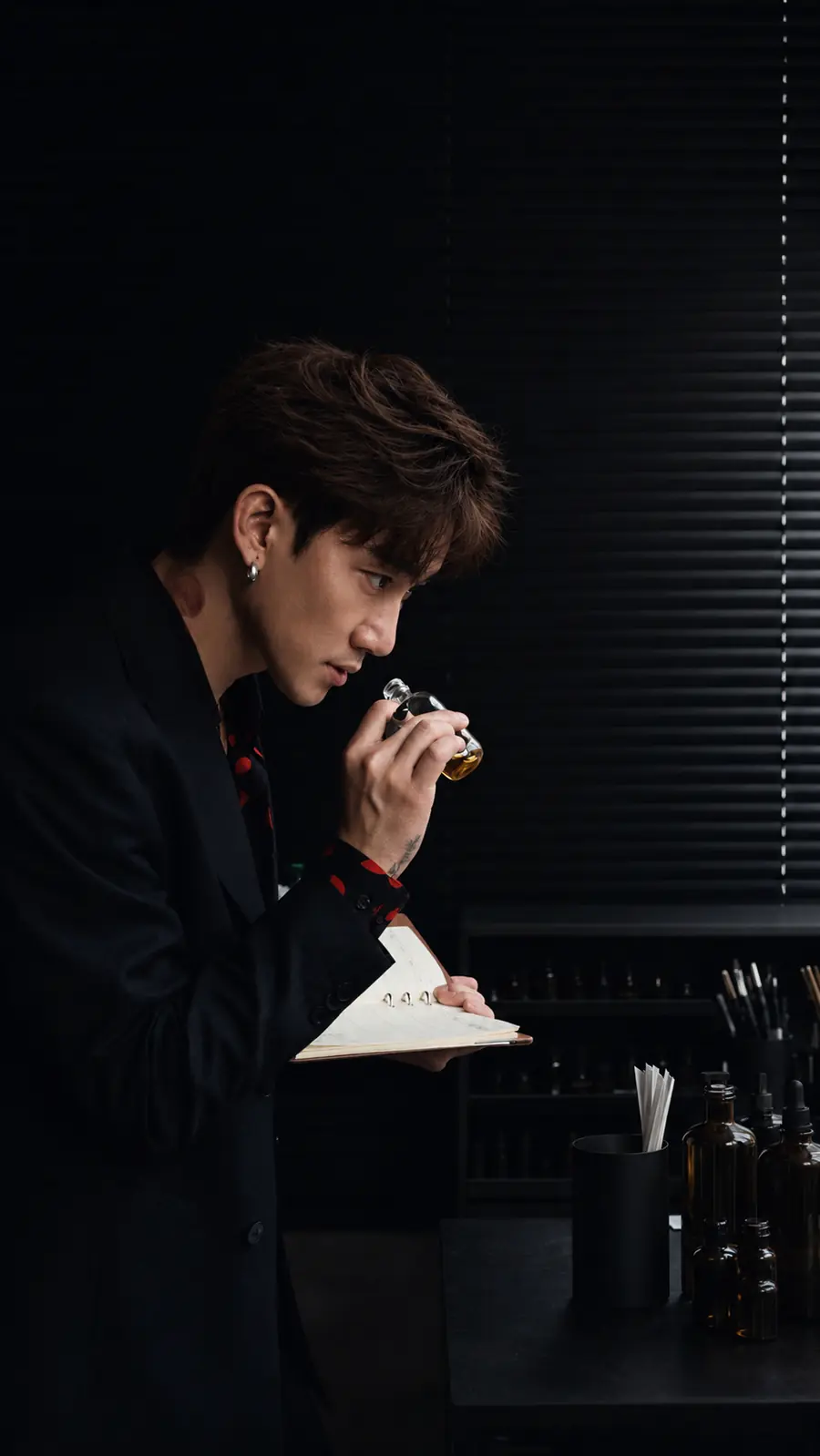 Aven Xu smelling a fragrance in the studio